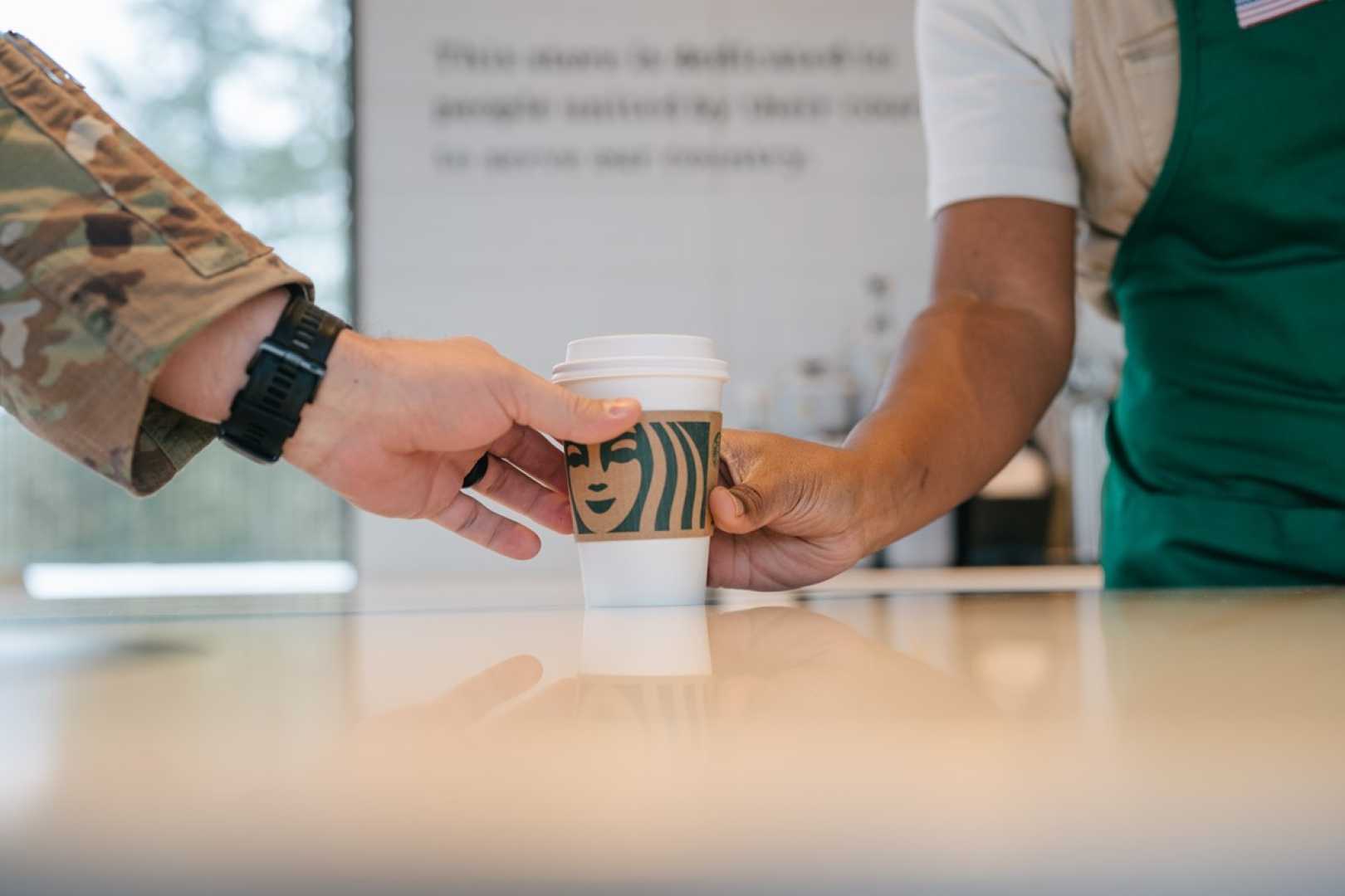 Starbucks Barista Handing Free Coffee Cup