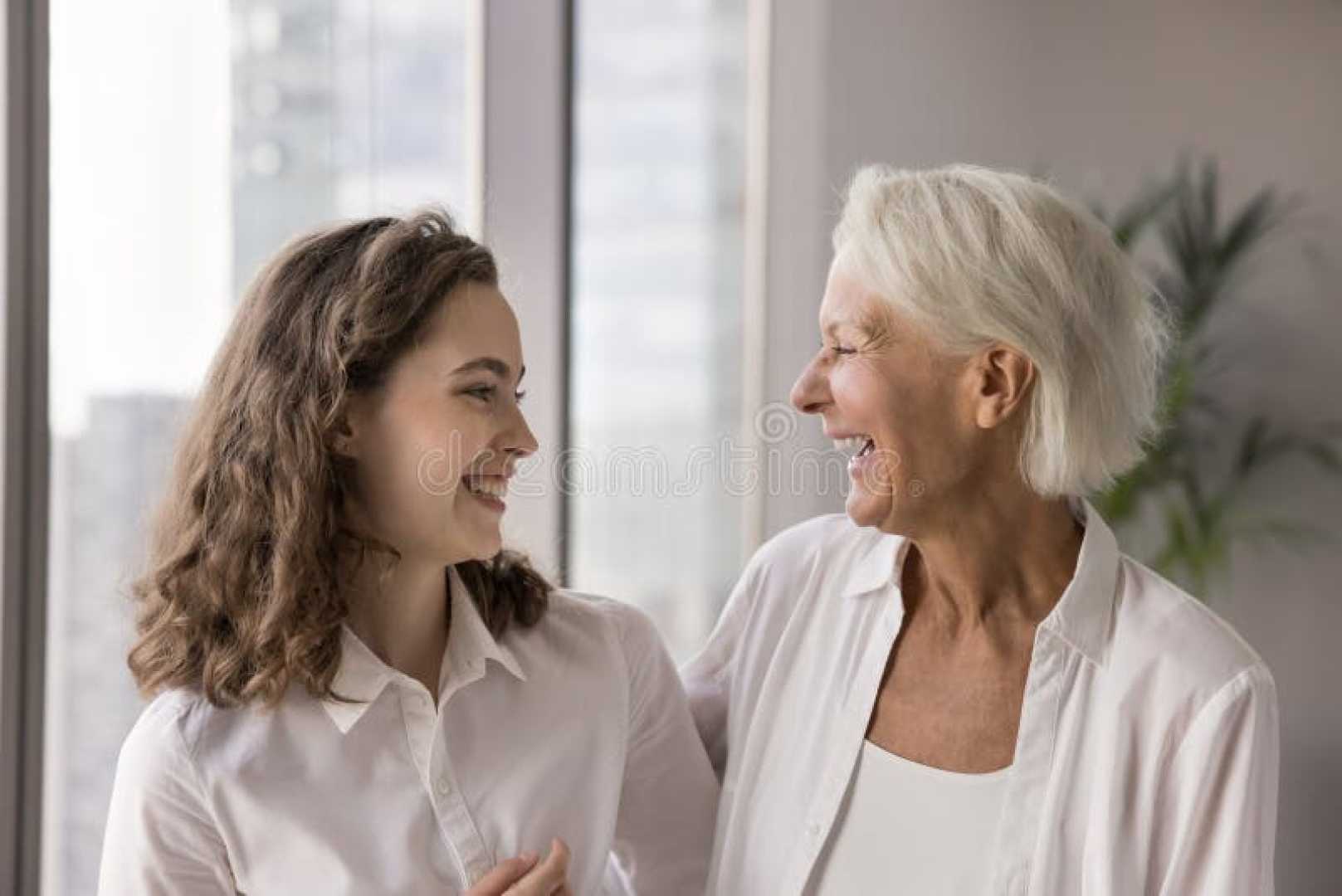 Young Teacher And Older Colleague Laughing Together